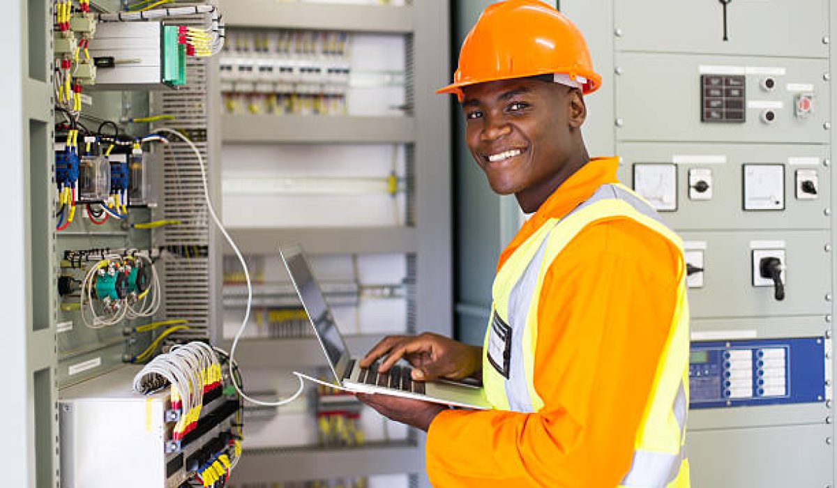 african electrical worker using laptop computer checking transformer